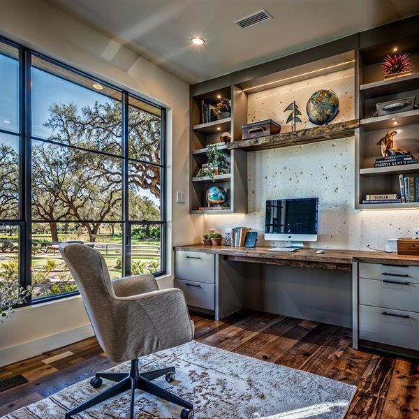 Office space featuring dark wood-type flooring, visible vents, and built in study area