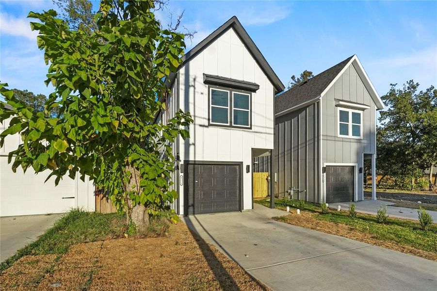 Modern farmhouse with board and batten siding, an attached garage, concrete driveway, and roof with shingles Modern farmhouse with board and batten siding, an attached garage, concrete driveway, and roof with shingles