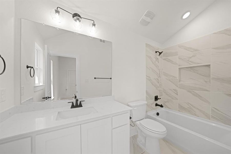 Bathroom featuring shower / tub combination, vanity, and lofted ceiling Bathroom featuring shower / tub combination, vanity, and lofted ceiling