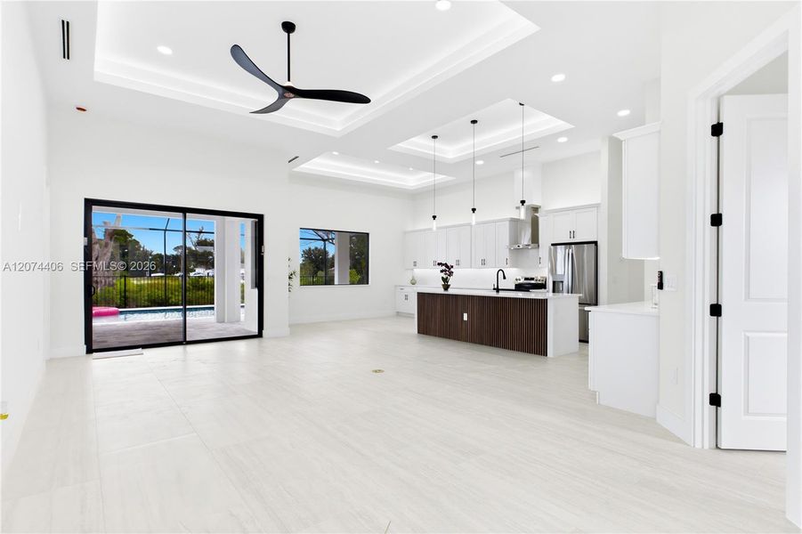 IMPACT-RESISTANT DOUBLE DOORS lead into WELCOMING LIVING ROOM w/ 14-ft VOLUME CEILING & SLIDING DOORS TO LANAI. IMPACT-RESISTANT DOUBLE DOORS lead into WELCOMING LIVING ROOM w/ 14-ft VOLUME CEILING & SLIDING DOORS TO LANAI.