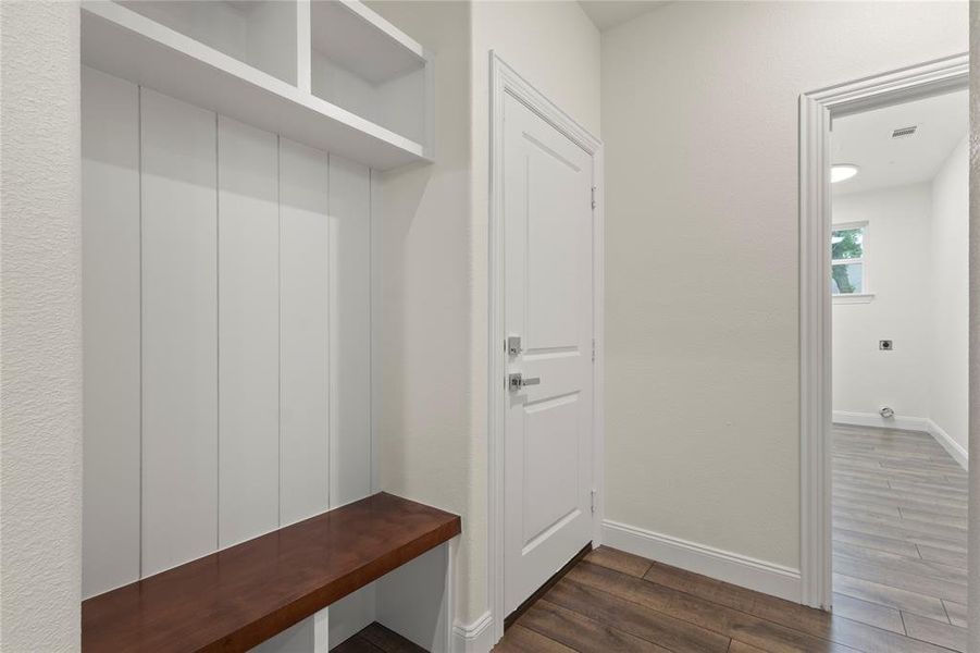 Built-in drop zone with a wood-finish bench and overhead storage cubbies Built-in drop zone with a wood-finish bench and overhead storage cubbies