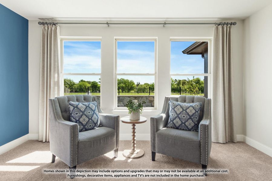 Sitting area with two gray armchairs and small side table beside three large windows with outdoor views Sitting area with two gray armchairs and small side table beside three large windows with outdoor views