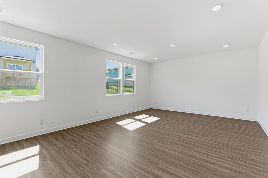 A room with a wood floor and windows.