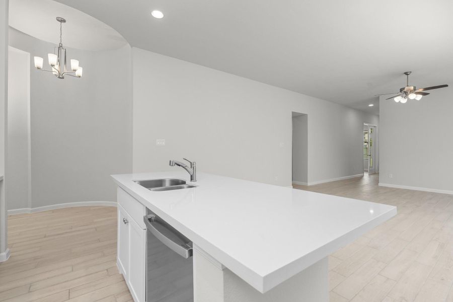 Large kitchen island overlooking the dining and living areas in this open-concept home.