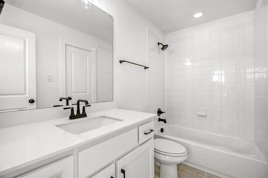 Full bath with shower / tub combination, vanity, light tile patterned flooring, and recessed lighting
