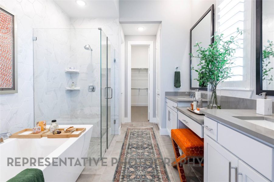 Bathroom featuring double vanity, a shower stall, a spacious closet, a freestanding bath, and light tile patterned flooring Bathroom featuring double vanity, a shower stall, a spacious closet, a freestanding bath, and light tile patterned flooring
