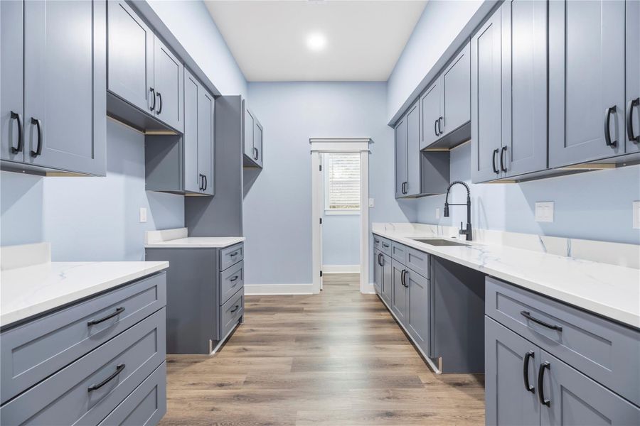 Modern kitchenette with extensive cabinetry, sleek countertops in private guest quarters.