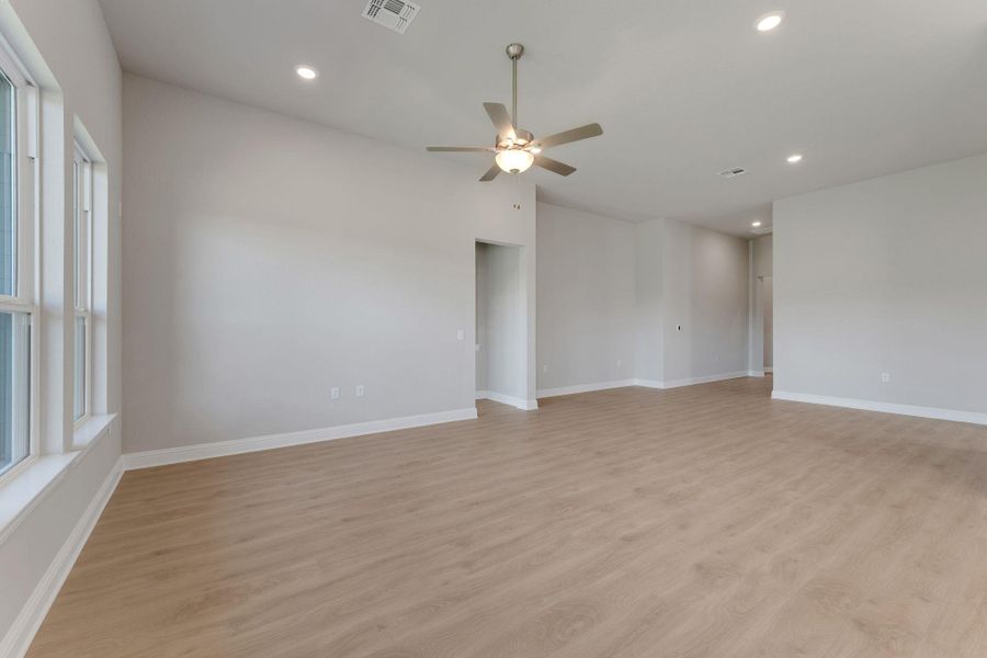 Empty room with ceiling fan, light wood-style flooring, recessed lighting, and lofted ceiling Empty room with ceiling fan, light wood-style flooring, recessed lighting, and lofted ceiling