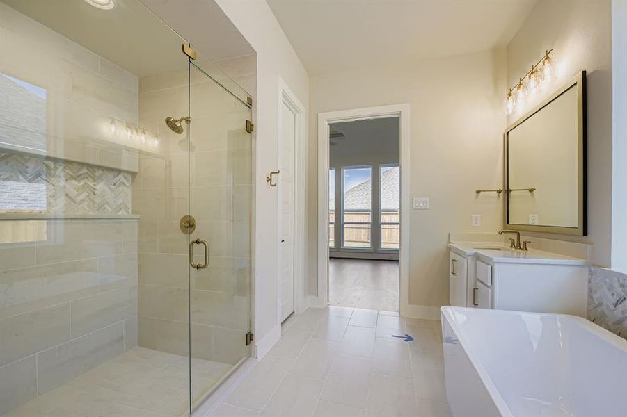 Bathroom featuring a stall shower, a soaking tub, vanity, and light tile patterned flooring