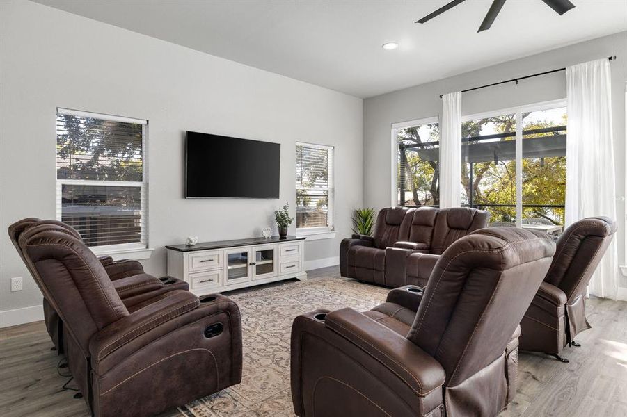 Living area featuring light wood-style flooring, ceiling fan, and recessed lighting