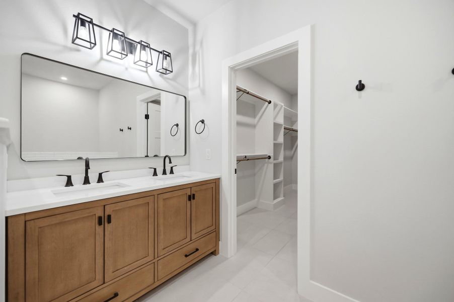 A well-appointed vanity with dual sinks and ample storage, complementing the adjoining walk-in closet. A well-appointed vanity with dual sinks and ample storage, complementing the adjoining walk-in closet.