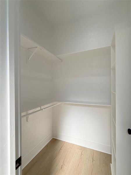 Spacious master walk-in closet with ample storage and organized walk-in closet with built-in shelving, hanging rods, and ample space for your wardrobe.