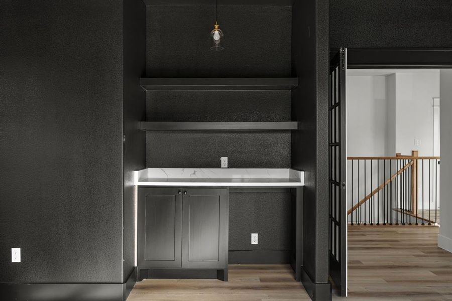 Bar area in game room and a Staircase featuring hardwood / wood-style floors