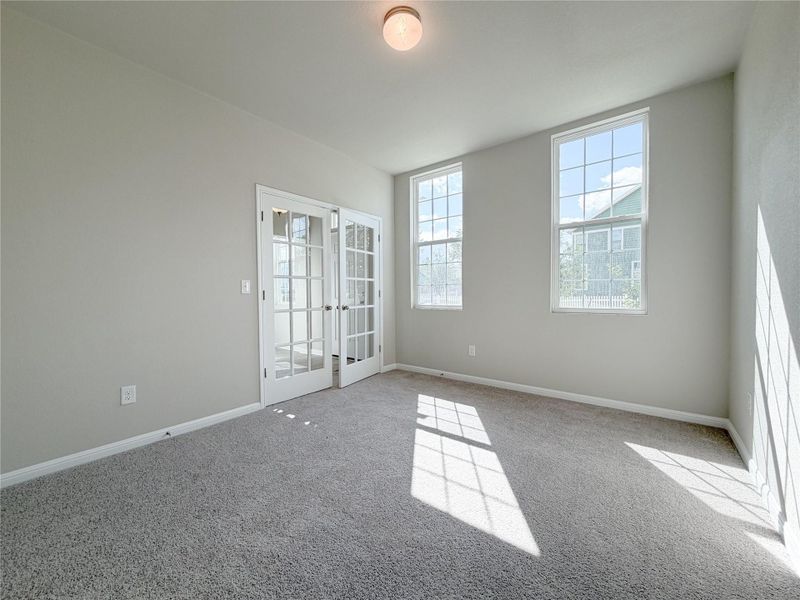 Spacious room featuring neutral carpeting and light-toned walls