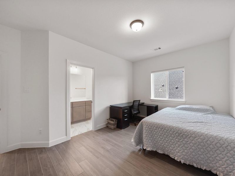 This secondary bedroom includes its own private ensuite bath, making it ideal for an older child, teen, or visiting guest who appreciates added privacy.