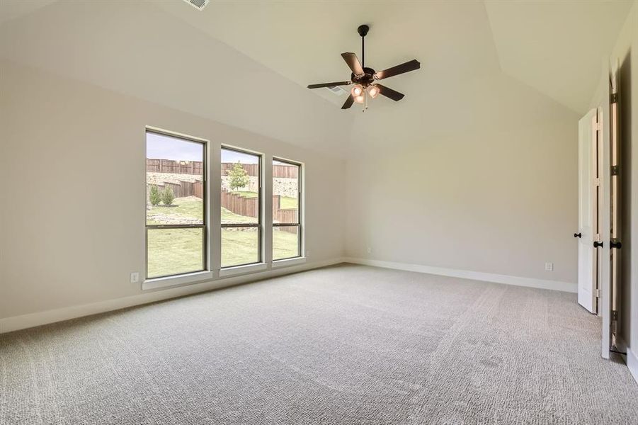 Spare room featuring light carpet, a ceiling fan, and high vaulted ceiling Spare room featuring light carpet, a ceiling fan, and high vaulted ceiling