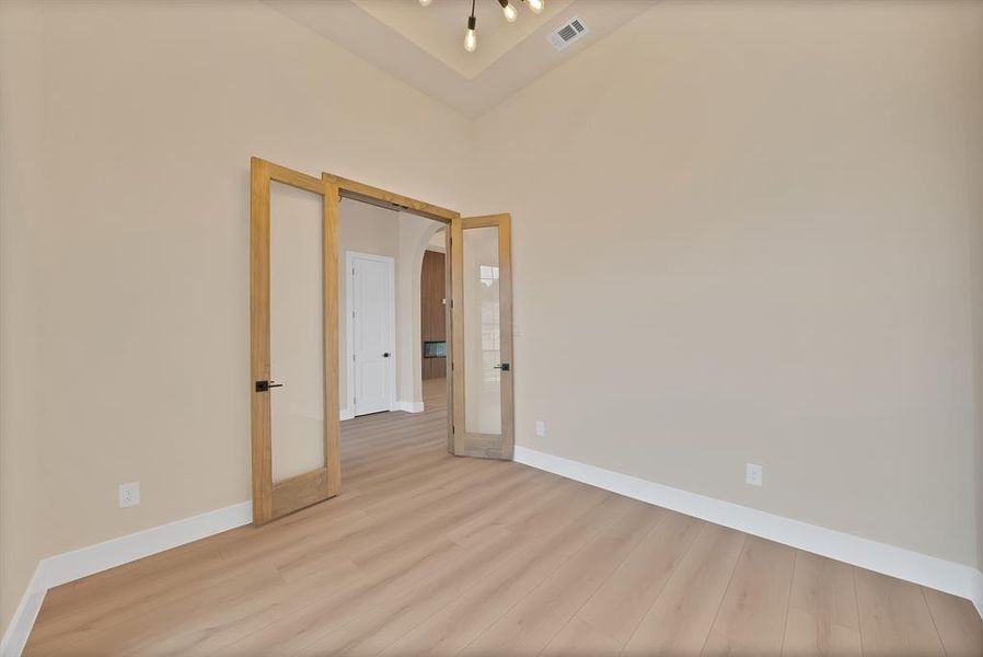 Empty room featuring wood finished floors and french doors Empty room featuring wood finished floors and french doors