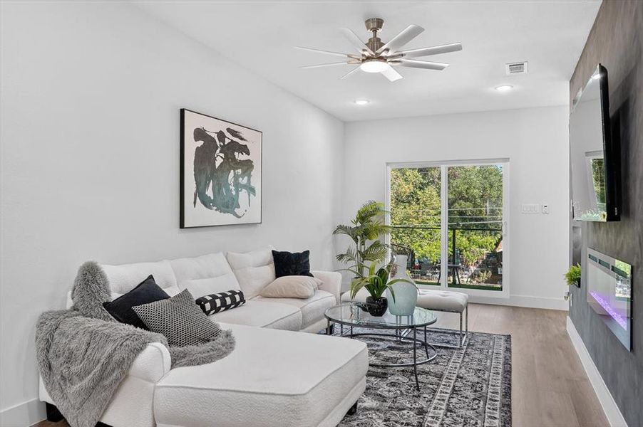 Wood-finish flooring throughout, complemented by a modern ceiling fan with integrated lighting