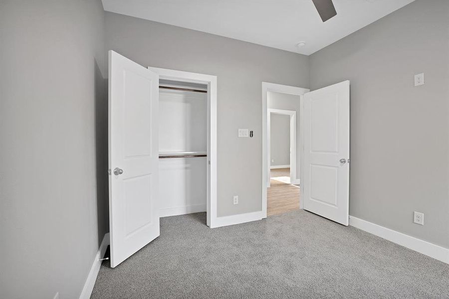 Unfurnished bedroom with light colored carpet, a closet, and ceiling fan