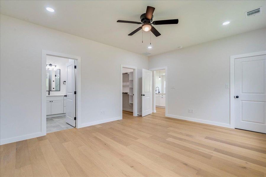 A generously proportioned sleeping area boasts light hardwood flooring, in suite bathroom and walk in closet.