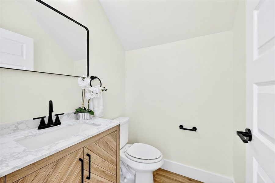 Vanity featuring a patterned wood-finish base, integrated white sink, and stone-finish countertop