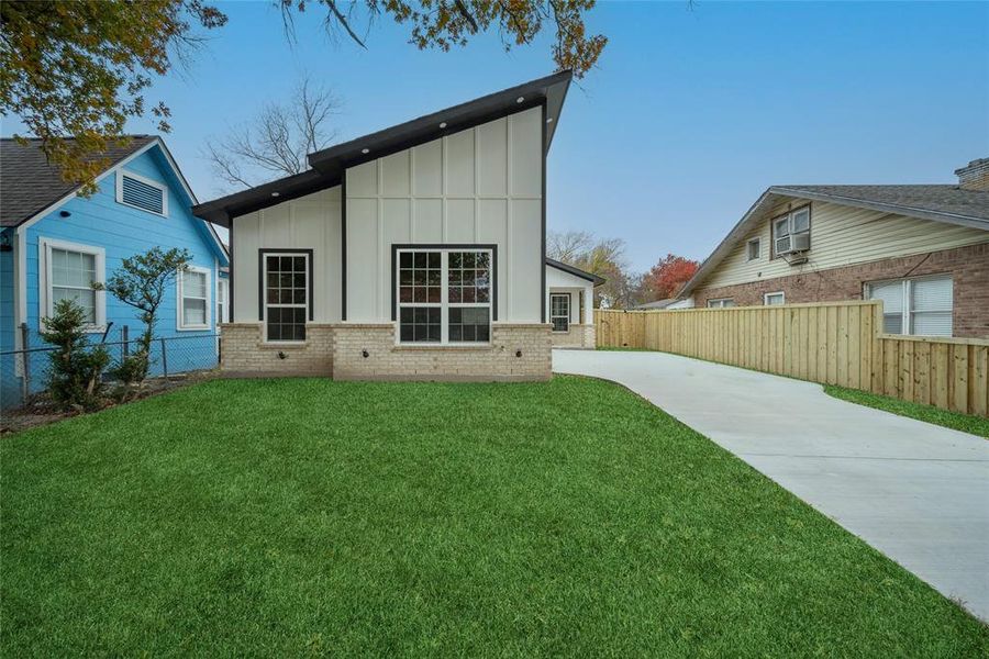 Rear view of property with a yard