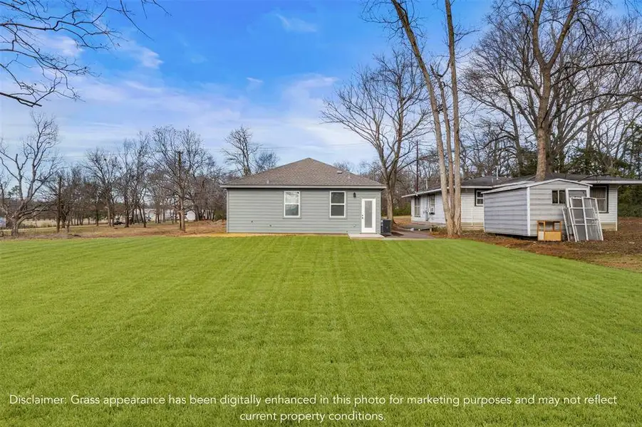 Back of house with a lawn, a patio area, and roof with shingles
