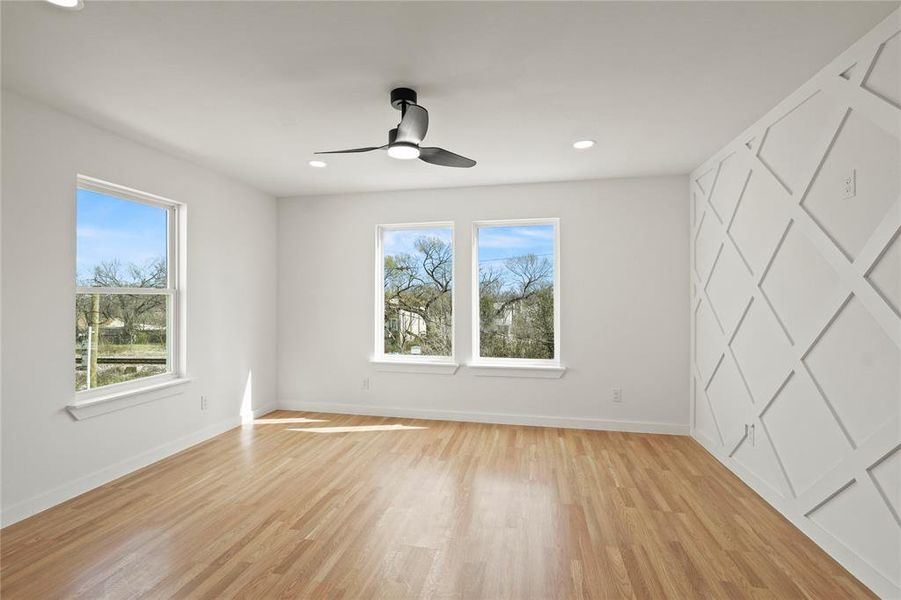 Unfurnished room with ceiling fan and light wood-type flooring