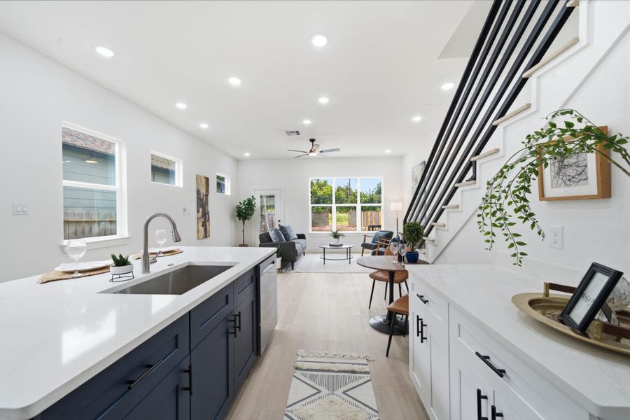 High-end quartz counters that run up the backsplash, added counter and cabinetry, and a large walk-in pantry that runs under the stairs.