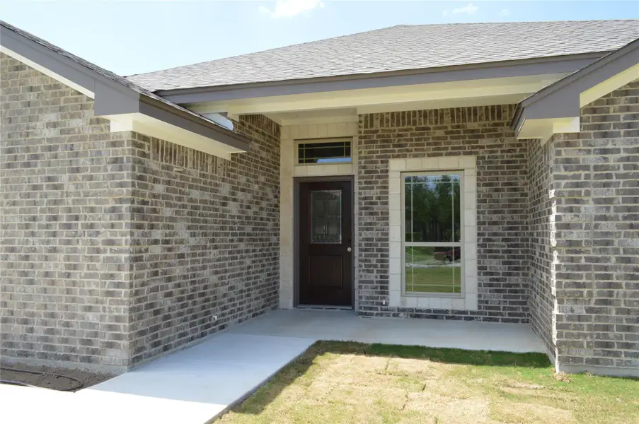 Doorway to property featuring brick siding