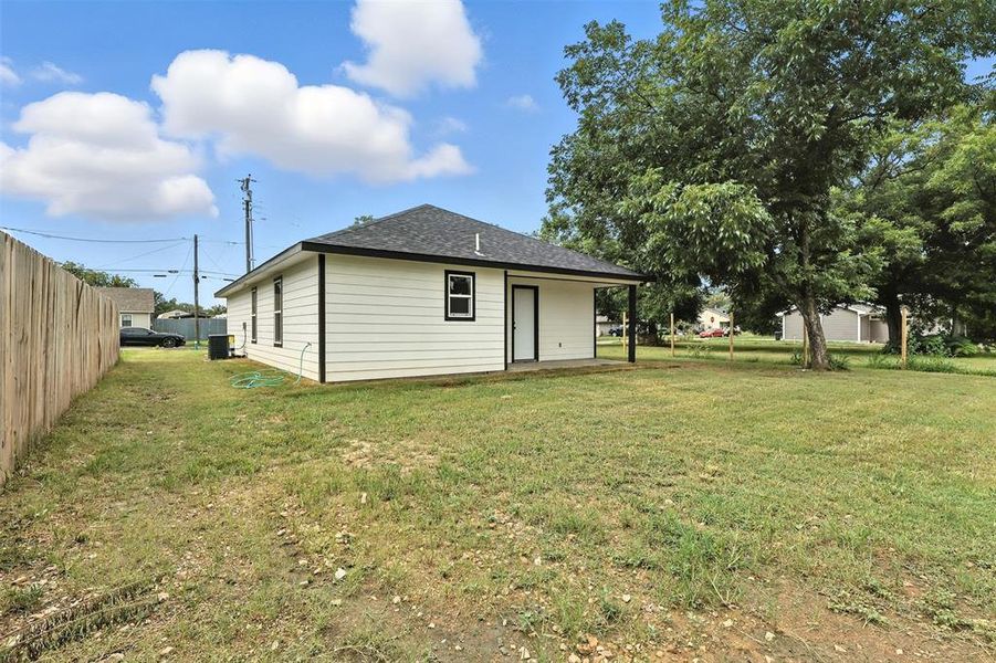 Back of house featuring a shingled roof Back of house featuring a shingled roof
