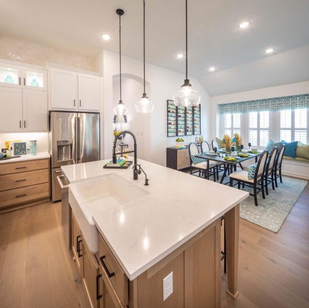 Kitchen featuring recessed lighting, hanging light fixtures, white cabinets, light wood-style floors, and stainless steel fridge