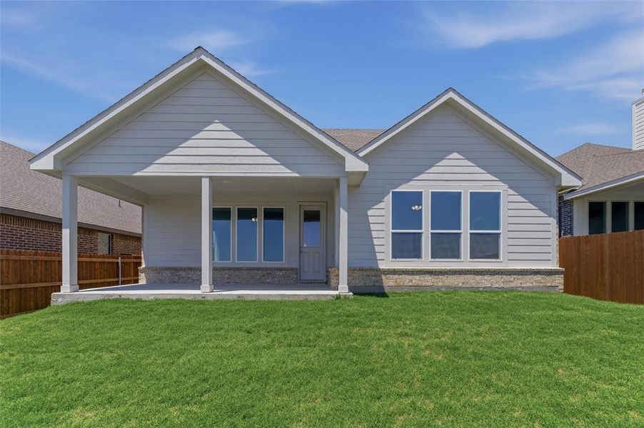 Rear exterior featuring light-colored horizontal siding and stone veneer accents