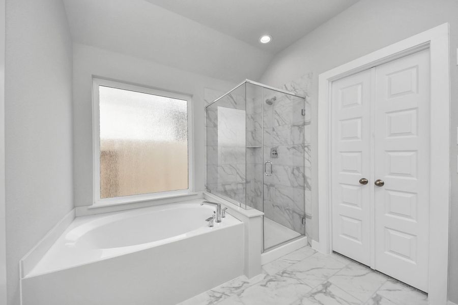Indulge in a spa-like retreat within the confines of this primary bathroom. Delight in a spacious walk-in shower enveloped in stylish tile surround and unwind in a separate garden tub adorned with custom detailing. Indulge in a spa-like retreat within the confines of this primary bathroom. Delight in a spacious walk-in shower enveloped in stylish tile surround and unwind in a separate garden tub adorned with custom detailing.