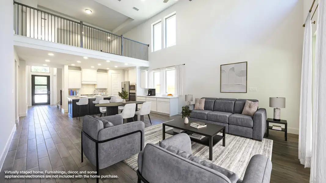 Living area with baseboards, dark wood-style floors, a healthy amount of sunlight, and a towering ceiling Living area with baseboards, dark wood-style floors, a healthy amount of sunlight, and a towering ceiling