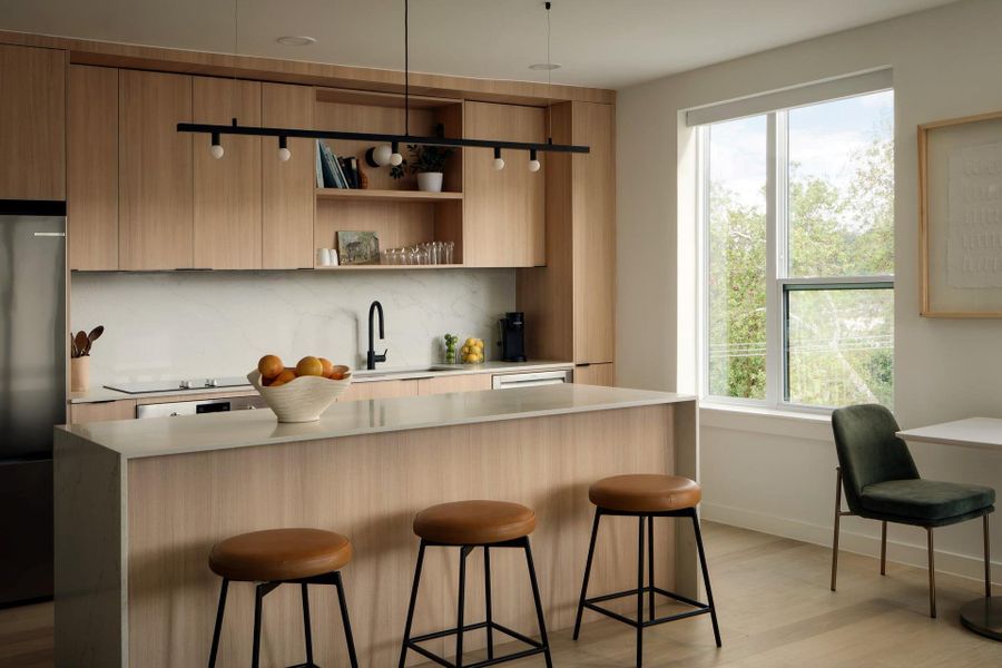 Natural wood cabinetry and a central island highlight this modern, light-filled kitchen space. Natural wood cabinetry and a central island highlight this modern, light-filled kitchen space.