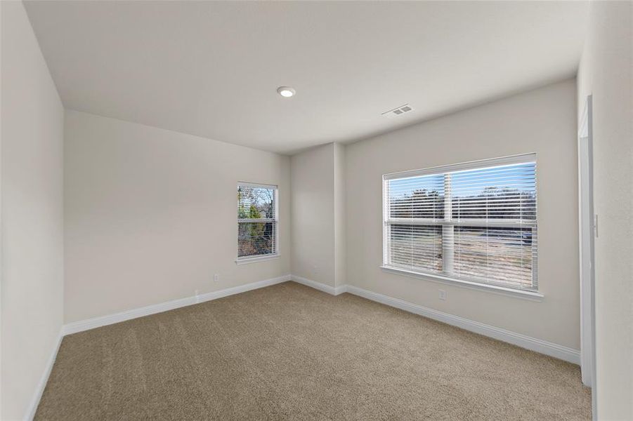 Spare room with baseboards and light colored carpet