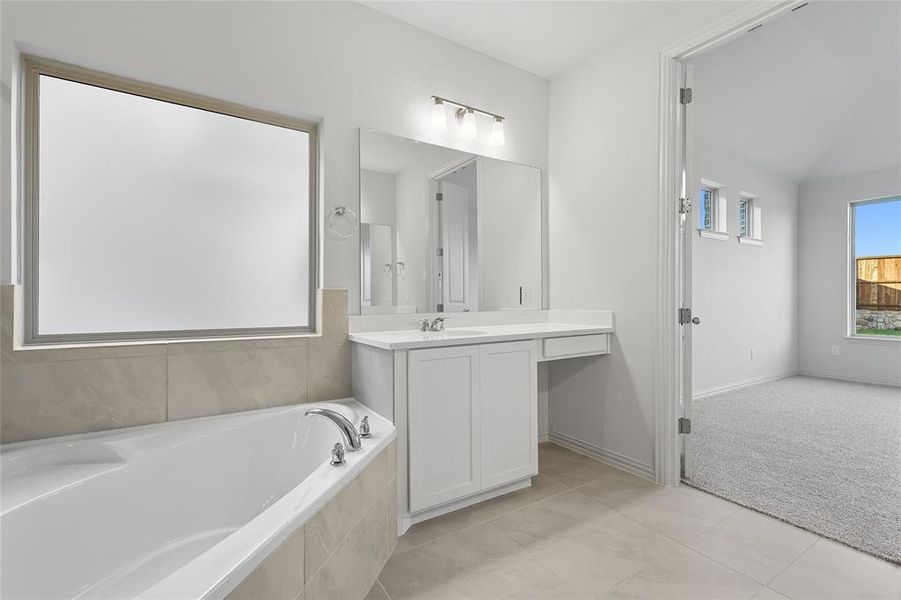 Bathroom featuring a bath, vanity, and light tile patterned floors Bathroom featuring a bath, vanity, and light tile patterned floors