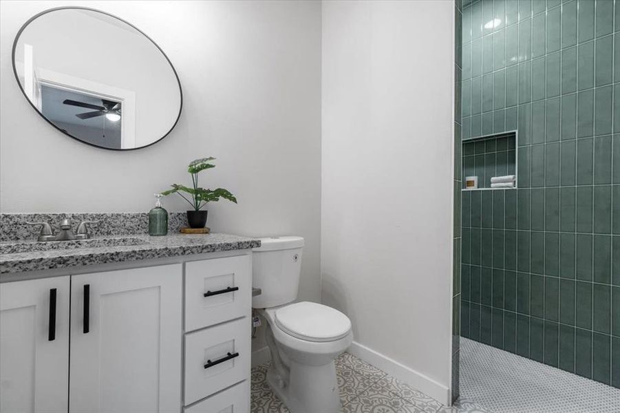 Bathroom featuring vanity, toilet, tile patterned floors, and ceiling fan