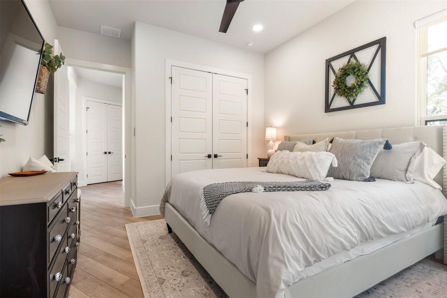 Bedroom with ceiling fan and light wood-type flooring Bedroom with ceiling fan and light wood-type flooring
