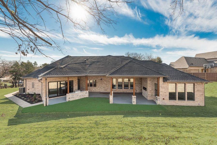 Back of property featuring a lawn, cooling unit, and a patio area