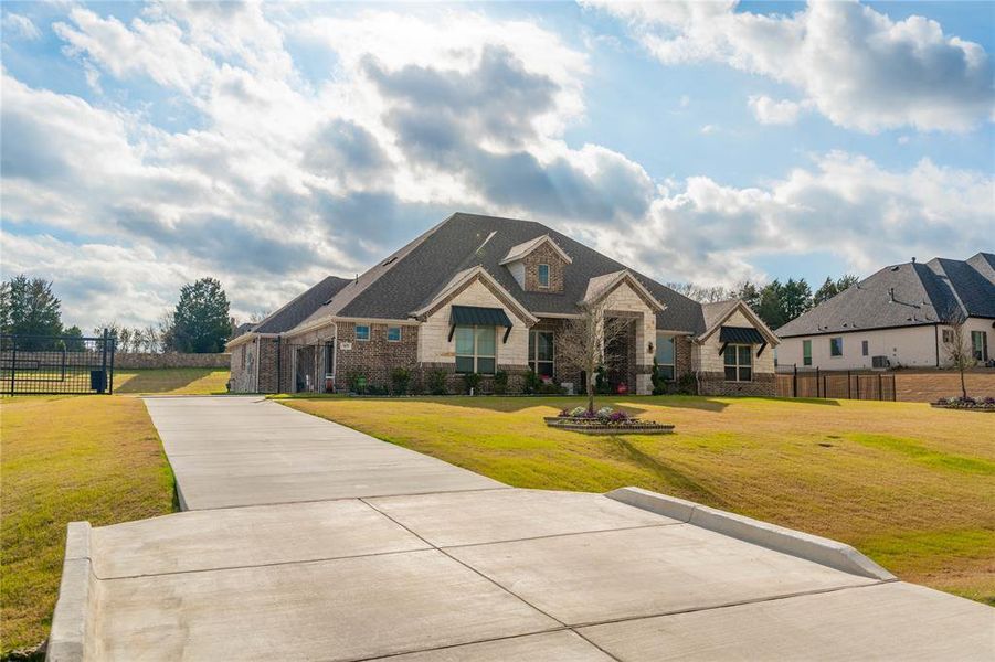 View of front of house with stone siding and concrete driveway