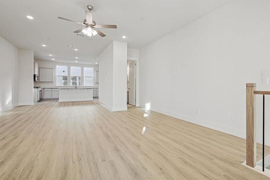 Unfurnished living room with recessed lighting, light wood-style flooring, baseboards, and ceiling fan