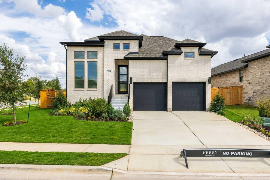 View of front facade featuring brick siding, driveway, a garage, roof with shingles, and a gate View of front facade featuring brick siding, driveway, a garage, roof with shingles, and a gate