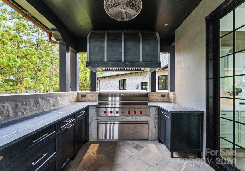 Covered Grilling patio with solid stone countertops and plenty of storage featuring a Wolf grill.