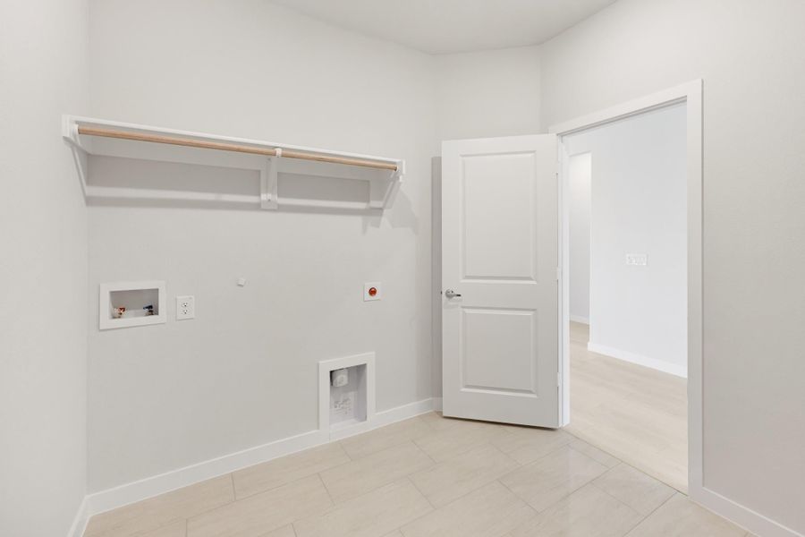 Laundry room with wall-mounted clothes rod, washer hookups, and tile floor
