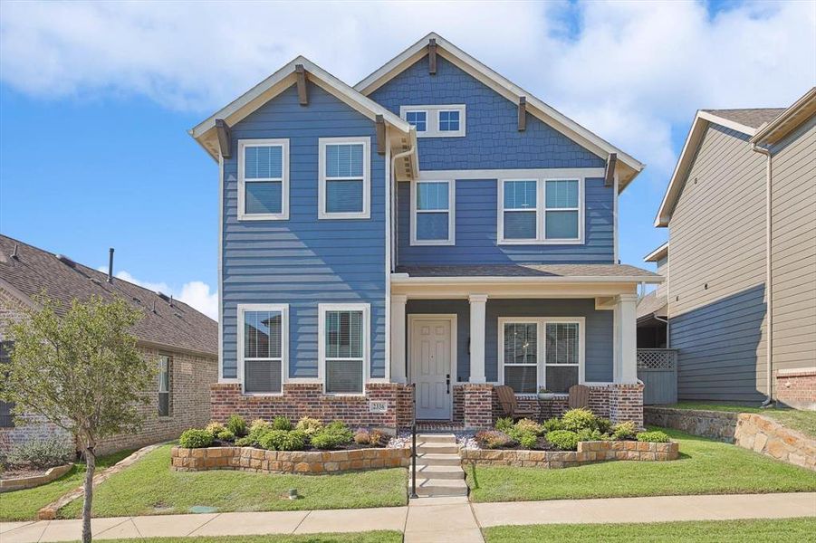 Craftsman inspired home featuring covered porch and a front yard