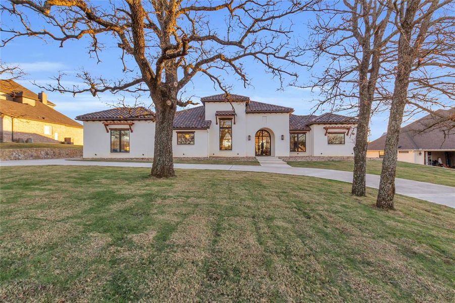 Mediterranean / spanish-style home with a front yard