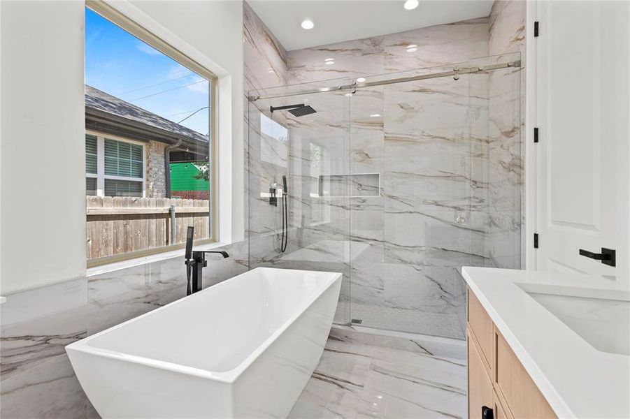 Bathroom with tile walls, plenty of natural light, and vanity