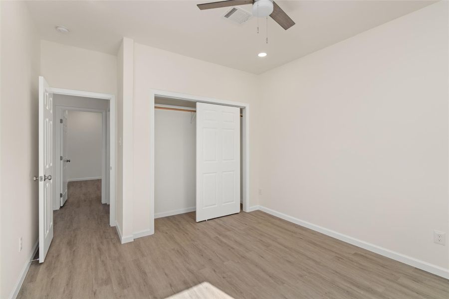 Spacious bedroom with ample closet space and clean, modern finishes.